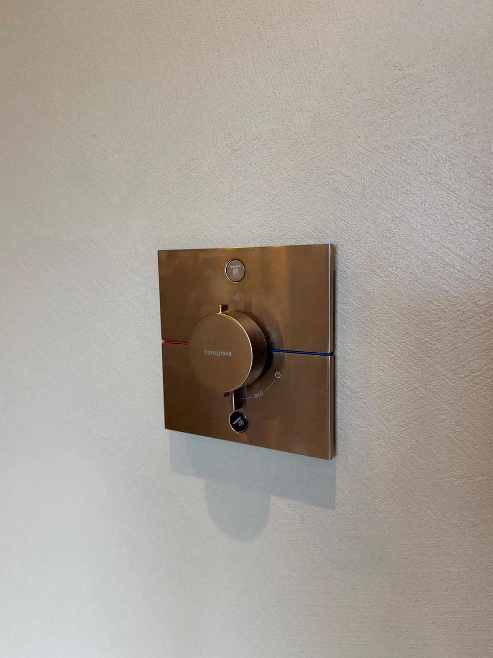 Bronzefarbene Armatur bündig in fugenloser Wand